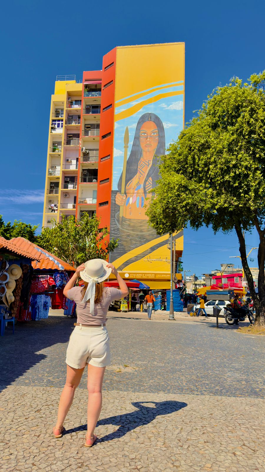 Mural da Índia em prédio do centro de Manaus, com barracas de artesanato ao redor