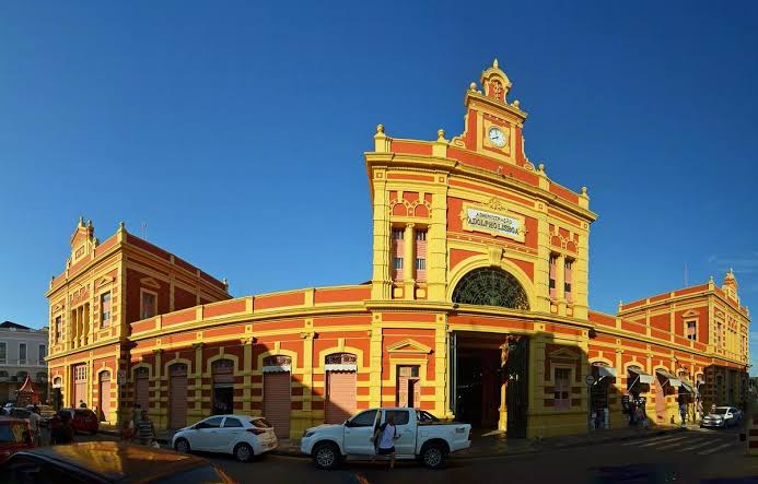 Fachada amarela e vermelha do Mercado Municipal Adolpho Lisboa ao fim da tarde