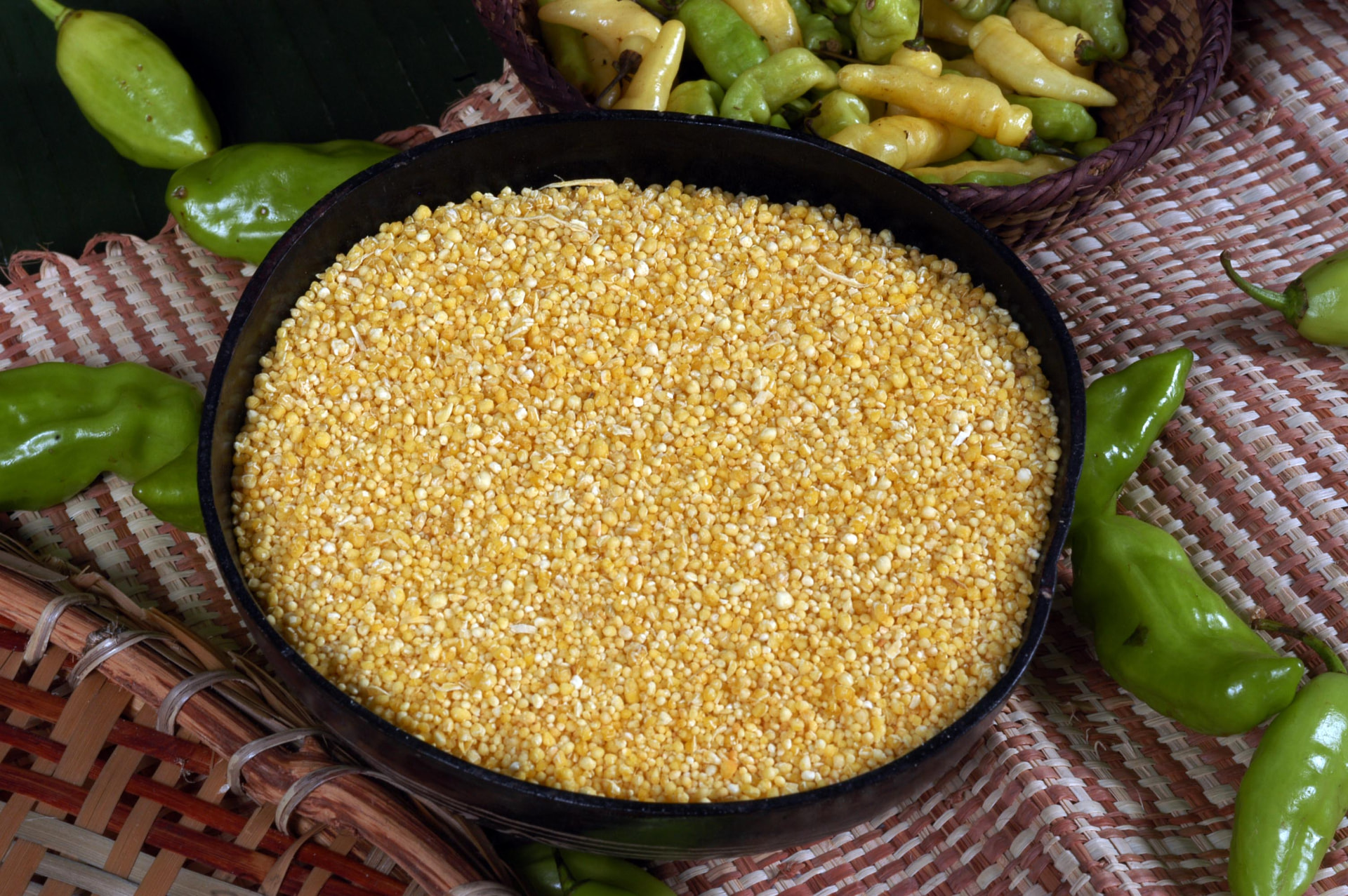 Tigela de farinha amarela sobre mesa de madeira