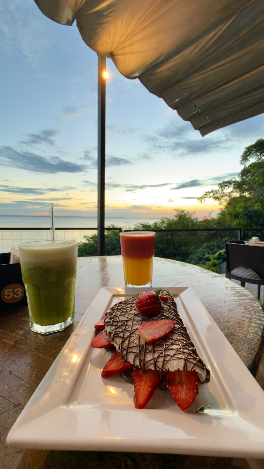 Varanda de café à beira do rio durante o pôr do sol